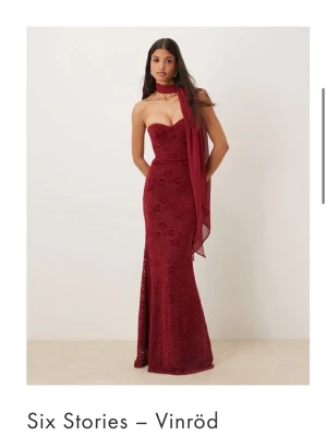 Vinröd långklänning från Six Stories - Elegant vinröd långklänning med spetsdetaljer och hjärtformad bandeau-överdel. Klänningen har sjal/scarf man kan ha till om man vill. Perfekt för bal eller festliga tillfällen. Nypris 2 129kr