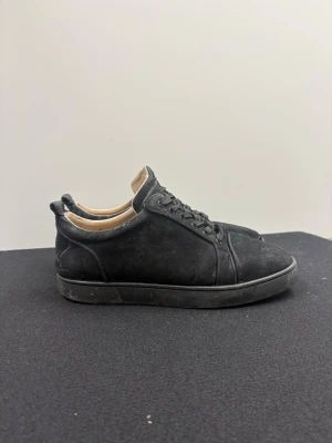 Christian Louboutin skor i svart - Stilrena svarta sneakers i mocka från Christian Louboutin med klassisk röd sula och snörning.  Priset kan diskuteras 💸