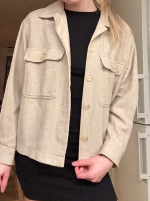 & Other Stories ulljacka - & Other Stories ulljacka, storlek S – fint skick Färg: Beige Material: Ull (exakt blandning okänd, lappen är tyvärr avklippt) Storlek: S Skick: Bra skick, använd men väl omhändertagen Notering: Kan kännas lite stickig för känsliga personer, typiskt för ullmaterial. Köpt för 1300 kr. Orderbekräftelsen sista bilden.