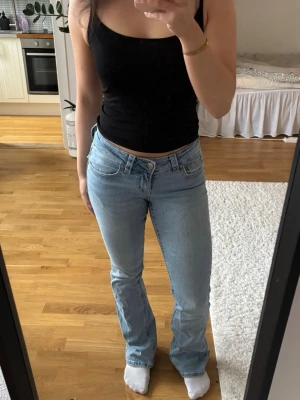 Ljusblå low waist bootcut jeans - Säljer ett par ljusblå bootcut jeans från Gina Tricot med låg midja. Jeansen har en snygg modell med stretchigt denim för skön passform.                                                  Jeansen har lätt slitage nedtill på jeansfållen pga användning, men överlag är byxora i bra skick!