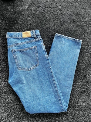 Weekday space jeans - Säljer ett par klassiska blå jeans från Weekday i rak modell. Jeansen har hög midja, fem fickor och knäppning med knappar. Tillverkade i kraftig denim med snygga kontrastsömmar. Perfekta för en avslappnad och trendig look. Storlek 31/34, straight/loose passar perfekt på mig som är 187, skick 9/10 förutom lite sliten längst ner på ena benet. Pris går att diskutera✅