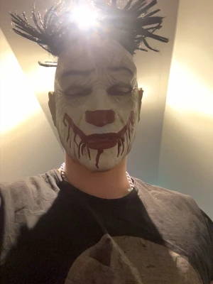Clownmask - Clownmask med stickade dreadlocks som sticker ut från toppen och ger ett unikt och edgy uttryck. Perfekt för dig som vill sticka ut och ha en alternativ stil. Materialet är troligtvis syntetiskt och masken har en klassisk form.