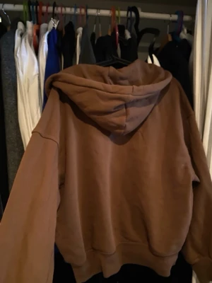 Brun oversized hoodie från H&M - Säljer en brun oversized hoodie från H&M i storlek M. Hoodien har en stor huva och ribbade muddar vid ärmslut och nederkant. Perfekt för en avslappnad och trendig look. Tillverkad i mjukt material som känns skönt mot huden.