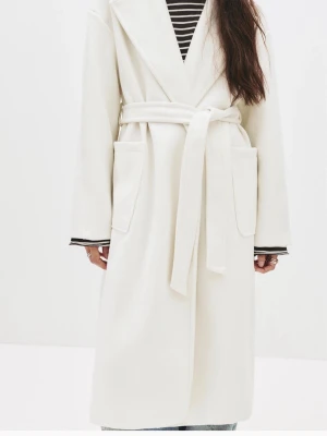 Vit kappa med knytskärp från Pull n Bear - Stilren vit kappa i lång modell med breda slag och knytskärp i midjan. Kappan har stora utanpåfickor och raka ärmar. Perfekt för dig som gillar minimalistisk och clean stil. Materialet är mjukt och något tjockare, passar bra till kyligare dagar men även nu till våren💕💕