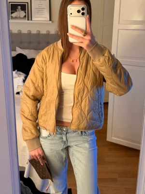 Beige dunjacka perfekt som vårjacka.  - Snygg beige dunjacka med quiltat mönster och ribbade muddar vid ärmslut. Står storlek 40 men jag som xs/ s kan ha den!