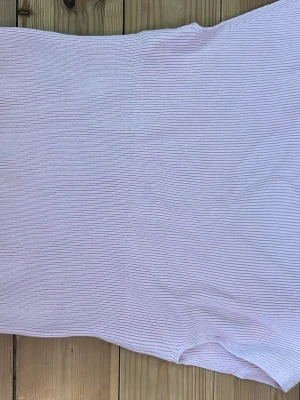 Ljusrosa ribbad ärmlös topp - Säljer en ljusrosa ribbad topp med ärmlös design. Toppen har en mjuk och stretchig känsla, perfekt för varma dagar eller som layering-piece. Enkel men stilren modell som passar till mycket.