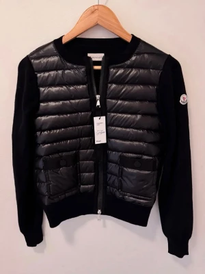 Moncler women cardigan - Bought on Vinted, officially verified (authentic). Stylish hybrid design with padded front and knitted sleeves, super warm yet lightweight. Color: Black Size: M Veritied authentic by Vinted