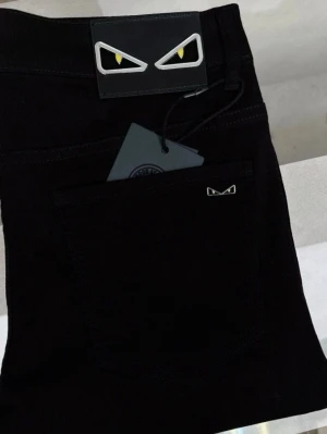 Svarta Fendi Monster jeans - W34 - Svarta jeans från Fendi med ikoniska Monster-ögon på bakfickan och läderpatchen. Slim fit-modell med klassisk femficksdesign och diskret metallogo. Snygga detaljer som sticker ut och ger en cool vibe till din outfit.