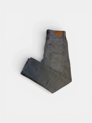 Grå Jack&Jones  jeans - Säljer ett par gråa jeans från Jack&Jones med klassisk femficksdesign och läderpatch bak i midjan. Jeansen har en vintage tvätt och är tillverkade i slitstark denim. Perfekta för en avslappnad och trendig look. W28 L32
