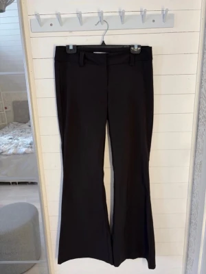 Svarta lågmidjade kostymbyxor - Säljer ett par svarta kostymbyxor med lågmidja och utsvängda ben, i stretchigt material. Dom är från H&M i storlek 40, men dom är små för sin storlek. Skulle säga mer som 36-38.                      Byxorna har några små knottror som jag tagit bild på, men inget som syns och annars som nya i skick. Hör gärna av dig om du har någon fråga!