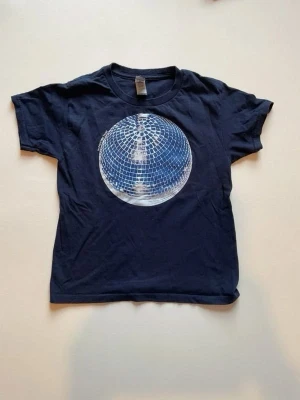 marinblå baby tee med discokula tryck - cool marinblå baby tee med ett stort tryck av en discokula i silver på bröstet. bilderna är ej mina.