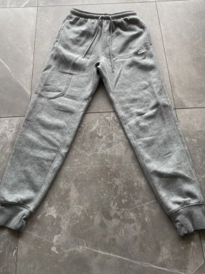 Gråa mjukisbyxor från Nike - Säljer dessa gråa mjukis byxor från Nike. Använda 3 gånger och som nytt skick.