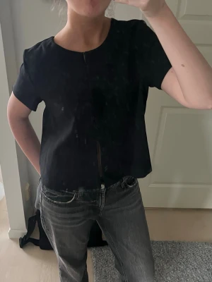 Svart topp med knappar - Snygg svart topp från Gina med knappar till magen!🌟