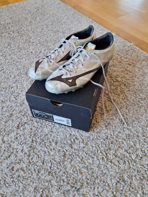 Mizuno Alpha II Made in Japan AG fotbollsskor  - Mizuno Alpha II Made in Japan AG fotbollsskor i storlek 43. Mycket bra skick, inga slitningar eller defekter finns. Dessa skor är sjukt bra för träning och match. Dem har en kolfiberplatta på främre undersulan och innersula som håller din fit fast i skon. Orginalbox, dustbag och handledningsbok ingår. Skick: 8/10