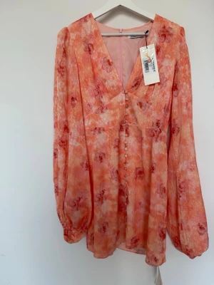 Florence peach Adoore - Säljer oanvänd klänning från Adoore. Lite mindre i storlek så gå gärna ner en size. Klänningen har lite fläckar bak (se bilder), går med stor säkerhet bort i tvätten. Jag kan tvätta innan leverans. Utöver det är den i toppskick.