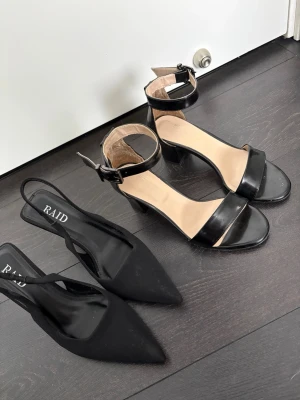 Två par svarta pumps från RAID - Säljer två par svarta pumps från RAID. Ena paret har öppen tå, bred rem över foten och justerbart ankelband med klack. Det andra paret har spetsig tå, smal rem runt hälen och smal klack. Båda paren är i svart material, ett par i matt och ett i glansigt. 1 för 150 båda för 200kr 
