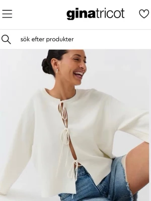 Vit tröja med knytning från Gina Tricot -  Vit långärmad tröja från Gina Tricot med knytning framtill. Tröjan har en lös passform och rund halsringning. Använd fåtal gånger.