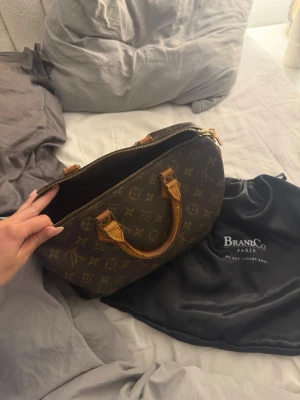 Louis Vuitton väska - Säljer denna snygga Luis Vuitton väska i modellen speedy 30.(se ältighetsbevis längre bak i bilder). Den är äkta men i halvbra skick (se bilder). Men ändå fräsch inuti och utvändigt🤎hör av er vid frågor