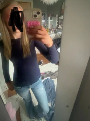 Mörkblå långärmad topp - En enkel och stilren mörkblå långärmad topp med rund hals. Passformen är slim och materialet ser ut att vara mjukt och stretchigt, perfekt för att matcha med jeans eller kjol.