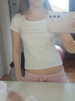 Vit croppad t-shirt med rund hals - Säljer en enkel och stilren vit t-shirt med croppad passform och rund hals. T-shirten har korta ärmar och är tillverkad i mjuk bomull, perfekt för en avslappnad och trendig look.