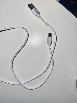 Vit USB till USB-C laddkabel - Säljer en vit USB till USB-C laddkabel som funkar perfekt för att ladda mobilen eller överföra data. Kabeln är flexibel och har en stilren design i plast. Passar de flesta Android-telefoner och andra enheter med USB-C-port.