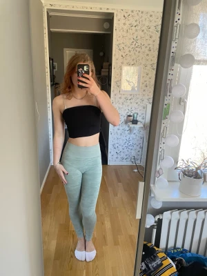 Ljusgröna leggings med hög midja - Säljer ett par ljusgröna leggings med hög midja och tight passform. De är mjuka och stretchiga.Materialet känns bekvämt mot huden och de har en enkel design utan synliga loggor.