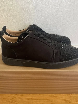 Svarta Louboutin sneakers med spikar - Svarta sneakers från Christian Loubotins, lätt använda, ända tecknet på användning är under skorn. Storlek 43 dock eftersom det är läder skor kan de passa 44 också.