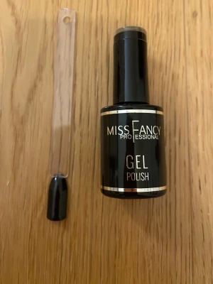 Miss Fancy Gel Polish Pitch Black - Snyggt svart gelnagellack från Miss Fancy Professional i färgen Pitch Black. Perfekt för dig som vill ha riktigt mörka, glansiga naglar. Kommer i en klassisk rund flaska med pensel för enkel applicering.