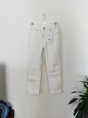 Vita raka jeans från denim Helt ny och oanvänd med prislapp kvar. - Snygga vita jeans från denim. med rak passform och klassisk femficksdesign. Jeansen har normal midja och är tillverkade i ett mjukt bomullsmaterial som ger en skön känsla. Perfekta för dig som vill ha en clean och stilren look.Helt ny och oanvänd med prislapp kvar.