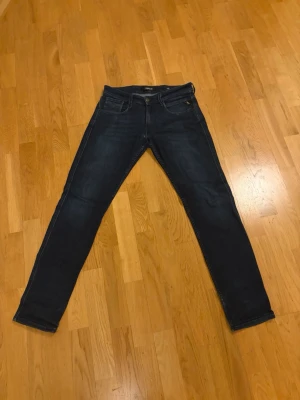 Mörkblå slim fit jeans - Snygga mörkblå slim fit jeans med klassisk femficksdesign och raka ben. Jeansen har diskreta kontrastsömmar och är tillverkade i ett stretchigt denimtyg som ger skön passform. Perfekta till en avslappnad streetstyle-look.
