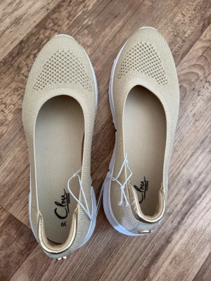 Beige ballerinaskor - Stilrena och helt nya beige ballerinaskor köpta från Skopunkten för 350kr, med stickad ovandel och vit, sportig sula. Skorna har rund tå och diskret mönster framtill. Perfekta för dig som gillar en enkel och modern look.