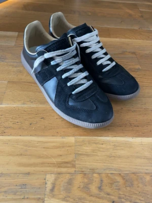 Svarta sneakers med mockadetaljer - Snygga svarta Maison Margiela Gats . OBS sista bilden är bara bild på boxen, skorna ser ej så nya ut nu men fortfarande skick 8/10
