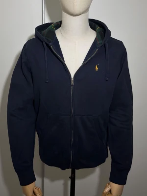 Polo Ralph Lauren Hoodie - Ralph Lauren The RL Fleece Full-Zip Hoodie Mörkblå. I jätte bra skick utan defekt som ny. Storlek M. Du kan alltid fråga för måtten ifall om du vill dubbelkolla. Skickar alltid samma dag eller nästa dag.