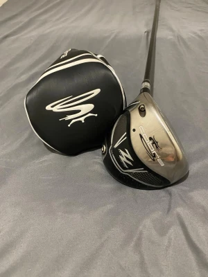 Cobra ZL Maximum Distance Driver//VÄNSTER - Säljer min Cobra ZL (Zero Limits) Maximum Distance Engineered Driver. som var designad för maximal distans! Cobra använde multi-material-konstruktion med lätt kolfiber i kronan och sulan kombinerat med ett starkt titanium-huvud för att sänka vikten och flytta tyngdpunkten bakåt och lågt. Resultatet blev högre launch, lägre spinn och längre bollflykt – många upplevde extra yards jämfört med samtida drivrar.   Loft 10.5 Skaft Regular, Aldila Voodoo S-Core Vänsterhänt  Grep orginala cobra  Headcove