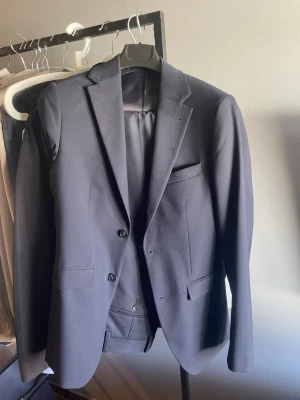 Mörkblå kostym från Riley - Säljer min marinblåa kostym från brothers märket Riley som är perfekt nu till skolavslutningar eller annat. Detta på grund av att den har blivit för liten. Kostymen är använd 1 gång och är i perfekt skick. Vid intresse är det bara att skriva så kan jag lösa fler bilder och svara på dina frågor. Priser är inte satt i sten. Galjen medkommer man kan även lägga till en vit shorta för 200 kr. Kavajen är storlek 44 och byxorna är storlek 46. 