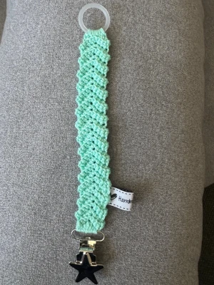 Virkad napphållare  - Virkad, mintgrön napphållare, virkad av mig i 100% bomullsgarn med metallclips och silikonring.  Mönsterskapare: animo.design