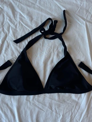 Svart trekantsbikini med knyt - Snygg svart trekantsbikini med knyt i nacken och ryggen. Märket är Soc och är i storlek 38!🖤