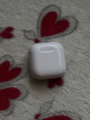 Vita trådlösa in-ear från Happy Plugs - Säljer ett par vita trådlösa in-ear hörlurar från Happy Plugs. De kommer i ett stilrent, blankt fodral som också fungerar som laddare. Hörlurarna har en smidig och modern design, perfekt för musik och samtal på språng.
