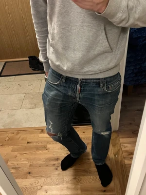 Blå slitna jeans från dsquared2  - Säljer ett par sköna blåa jeans från Dsquared2. Passar till allt och har fått en snygg tvätt.