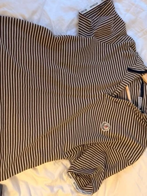 Randig Moncler t-shirt i bomull - Snygg vintage randig t-shirt från Moncler i brunt och vitt. Slå ett PM för fler bilder, pris går att diskuteras.