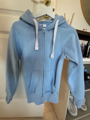 Ljusblå zip hoodie från Russemerch - Säljer min jätte fina hoodie från Russemerch då den är för liten. Använd en gång då jag prova den.