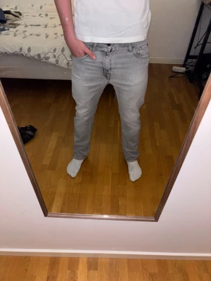 Ljusgrå Replay jeans - Säljer ett par ljusgrå Replay jeans med klassisk femficksdesign och dragkedjegylf. Jeansen har en modern passform som sitter normalt längs benen och är perfekta för en stilren vardagslook. Materialet är mjukt och stretchigt för extra komfort. Ord pris 799. Obs finns en liten slitning på baksidan (sista bilden) därmed det nedsänkta priset. 