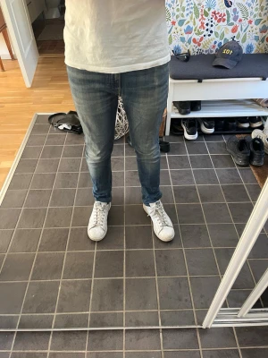 Calvin Klein jeans Blå slim fit jeans herr - Säljer ett par blå slim fit jeans med klassisk femficksdesign och smal passform. Jeansen har en snygg tvättad look och sitter tajt längs benen. Perfekta för dig som gillar en modern och stilren stil. W30 L32