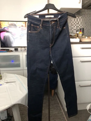 Mörkblå super skinny jeans - Mörkblå super skinny jeans från Quality Denim med klassiska fem fickor och kontrastsömmar. Hög midja och stretchigt material som sitter tajt längs benen. Perfekta för dig som gillar en slimmad siluett och enkel stil.