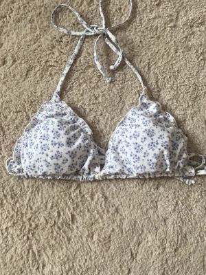 Vit blommig trekantsbikini från NOR - Supersöt trekantsbikini från NOR i vitt med små blå blommor.  Aldrig använd