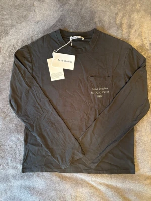 Långärmad Acne Studios Tröja  - Svart långärmad tröja från Acne Studios. Tröjan har endast testats och aldrig riktigt använts. Det finns inga tecken på användning tröjan ser helt ny ut. Tröjan har en lite oversized passform. Skriv för frågor och skicka gärna bud🤗