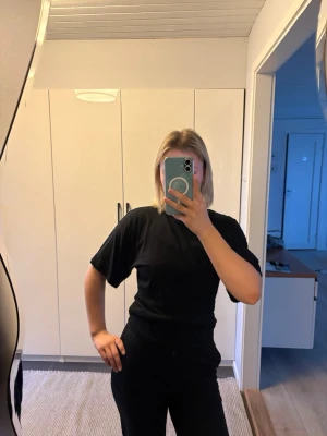 Svart basic t-shirt unisex - En enkel svart t-shirt med normal passform och korta ärmar. T-shirten är tillverkad i mjuk bomull och har en klassisk rund halsringning. 