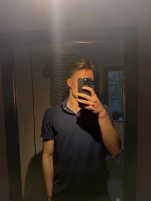 Blå piké från SAND - Klassisk blå piké från SAND. Storlek S men passar bra för de som har M: Modellen är 185 cm, 74 kg. Inga defekter och den är använd en gång så i princip som ny!