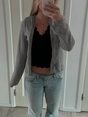Grå basic kofta i mjukt material - Grå koftan med en knapp upptill. Skön passform