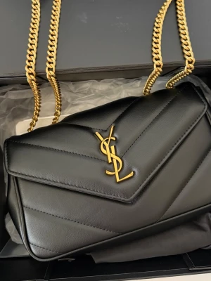 Svart väska i äkta skin  - Oanvänd svart väska i äkta skin kommer i box med en mini spegel och plånbok 